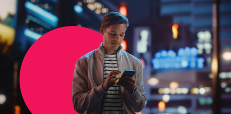 Man with a phone against a city backdrop at night